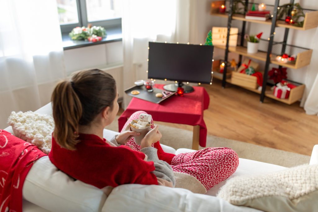 Person resting with a warm mug, symbolizing holiday self-care and emotional boundaries.